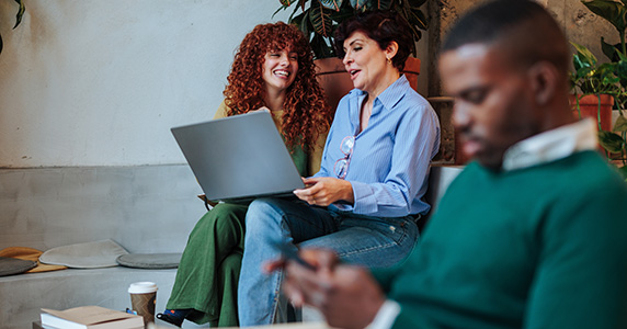 group of diverse employees in office receiving employee recognition on laptop