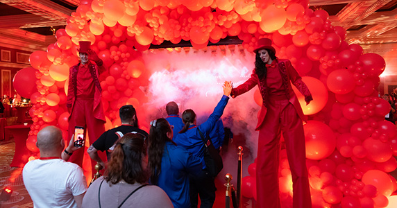 stiltwalkers greet franchisee event attendees at annual store manager meeting