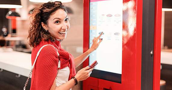 loyal customer ordering at a kiosk at a quick serve restaurant