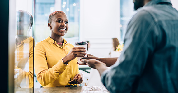 customer loyalty program participant ordering latte from barista at coffee shop