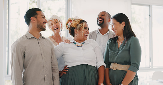 group of smiling, diverse employees working in a positive environment